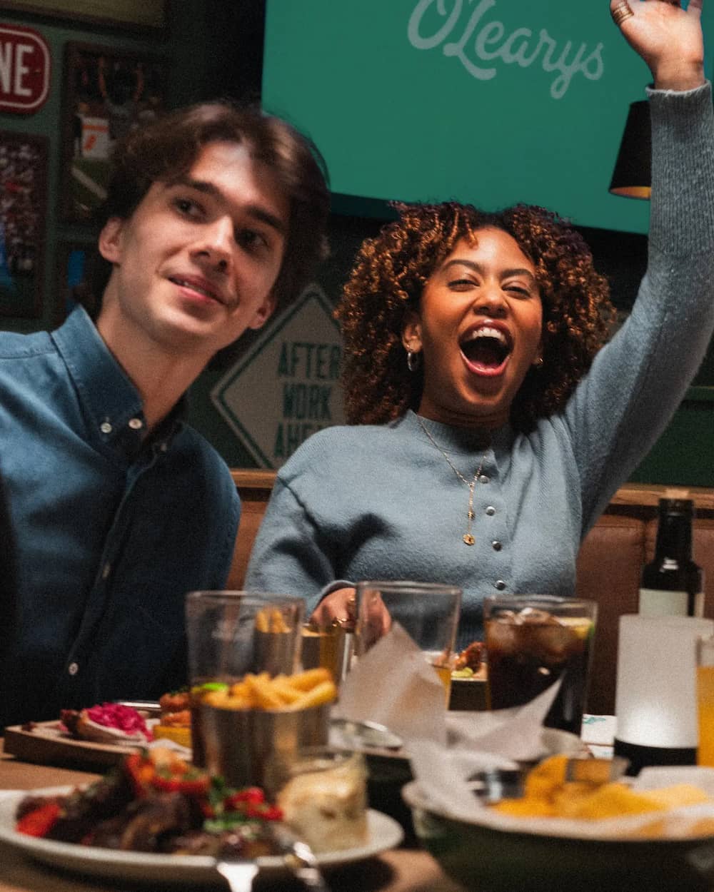 Två gäster njuter av mat och dryck i livlig restaurangmiljö med varm och social atmosfär. Perfekt för middagar, after work och kvällar där god mat, gemenskap och upplevelser står i fokus.